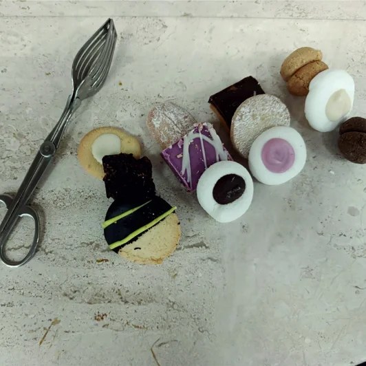 Praline e biscotti al cioccolato disposti sul piano di lavoro del laboratorio a Nuoro