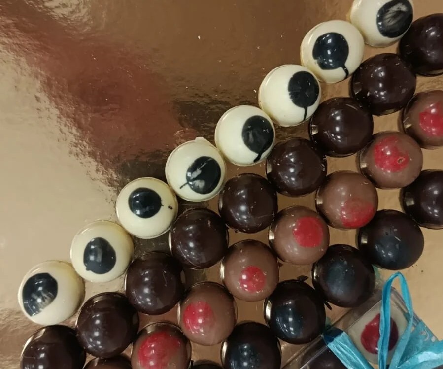 Praline di cioccolato fondente, al latte e bianco disposte su un vassoio a Nuoro
