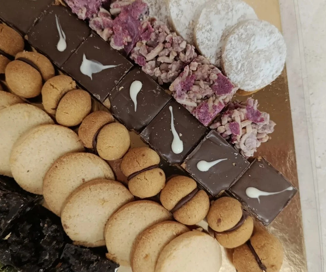 Quadrotti di cioccolato decorati accanto ai biscotti di un laboratorio a Nuoro